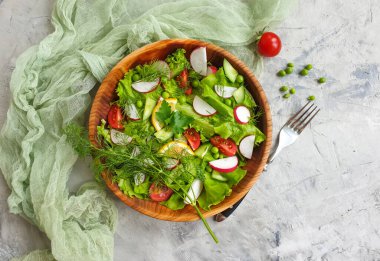 Beton arka planda bir tabakta salata