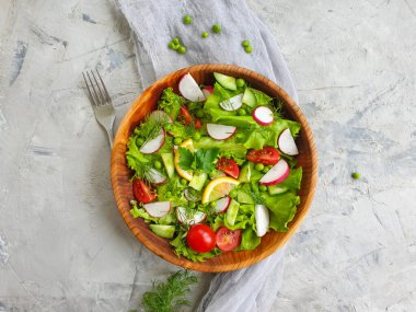 Beton arka planda bir tabakta salata