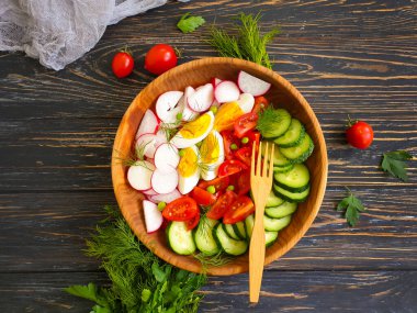 Tahta arka planda taze sebze salatası.