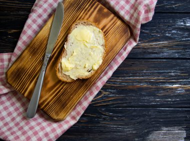 Tahta arka planda tereyağı, ekmek, maydanoz