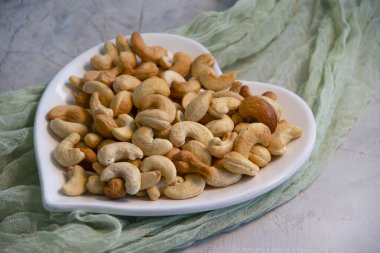  Beton arka planda bir tabakta ceviz, kalp.