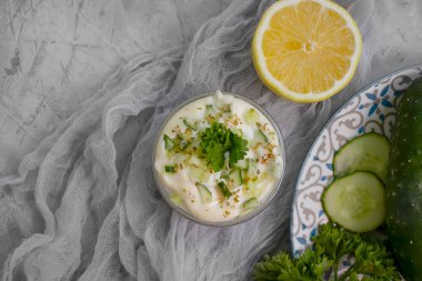  Tzatziki sosu, limon, beton zemin üzerinde salatalık.