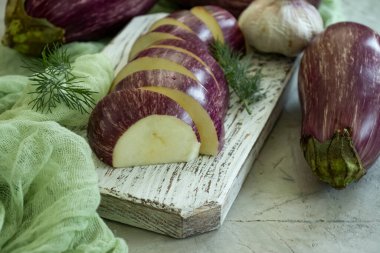 Beton zeminde dilimlenmiş çiğ patlıcan.