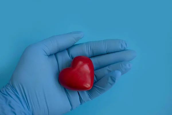 Χέρι Ένα Ιατρικό Γάντι Κρατά Μια Καρδιά — Φωτογραφία Αρχείου