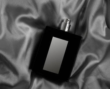 İpek arka planda bir şişe parfüm.