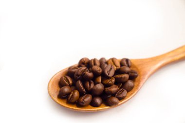 Tahta kaşık ve izole kahve taneleri.