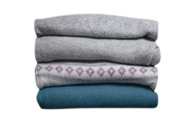 Beyaz arkaplanda izole edilmiş katlanmış sıcak giysi yığını