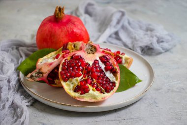 Beton arka planda bir tabakta nar meyvesi