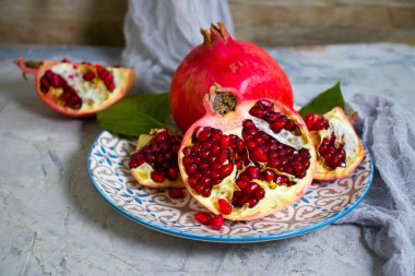 Beton arka planda bir tabakta nar meyvesi