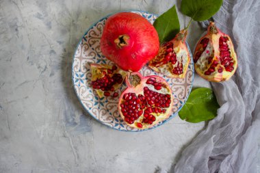 Beton arka planda bir tabakta nar meyvesi