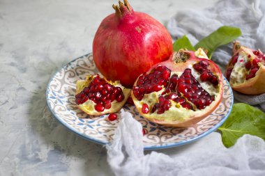 Beton arka planda bir tabakta nar meyvesi