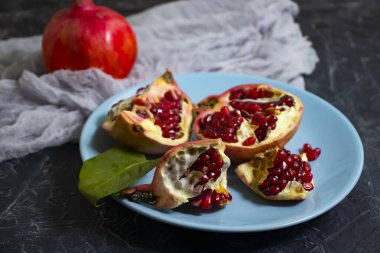Beton arka planda bir tabakta nar meyvesi