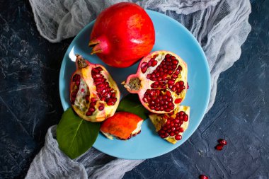 Beton arka planda bir tabakta nar meyvesi