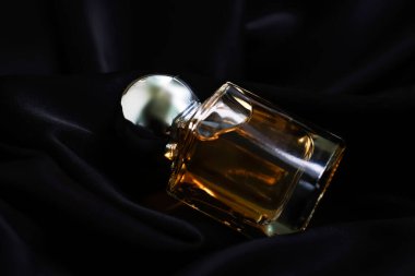 İpek arka planda bir şişe parfüm