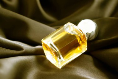 İpek arka planda bir şişe parfüm