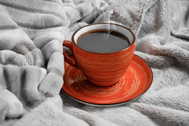 Sıcak bir battaniyede bir fincan kahve.