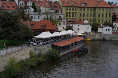 Nehrin kenarında beyaz çadırların altında açık hava restoranlarının yer aldığı bir karşılama restoranı var. Renkli binalar kıyı boyunca uzanır, büyüleyici bir gece atmosferi yaratır..