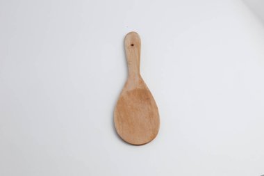Beyaz üzerine izole edilmiş tahta pirinç kaşığının üst görüntüsü. Yemek, mutfak ya da çevre dostu yaşam tarzı tasarımı için mükemmel bir görüntü..