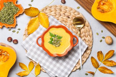Bir kase kabak çorbası, dokuma minderinde tohumlar ve otlar..