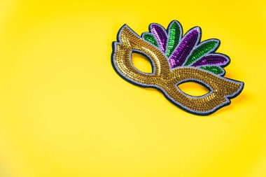 Parlak sarı arka planda renkli pul maskesi.