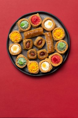 Geleneksel Kazak tatlıları ve abur cuburları, Nauryz kutlamaları için kırmızı arka planda hazırlandı..