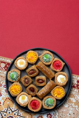 Geleneksel Kazak tatlıları ve abur cuburları, Nauryz kutlamaları için kırmızı arka planda hazırlandı..