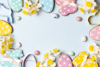 Paskalya çerçevesi pastel yumurtalar, çiçekler ve hafif arka planda şenlikli süslemelerden yapılmıştır..