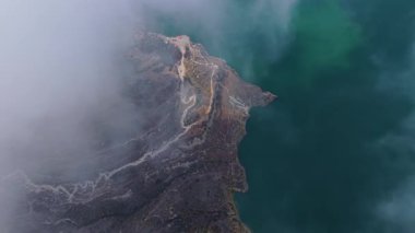 Volkanik krater gölü yoğun sis kütlelerinin altında kayboluyor. Havadan bakıldığında dağlık Ekvador manzarasını gizliyor..