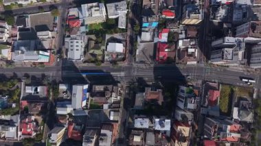 Quito, Ekvador kentsel manzarası, binaların çatıları, otobüslerin ve arabaların olduğu sokaklar ve kavşaklar hava perspektifinden gösteriliyor..