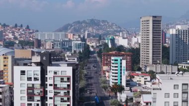 Quito 'nun canlı şehir manzarası Onbaşı Financiera Nacional binası ve El Panecillo tepesi, Andean dağ sırasının altındaki mimari karşıtlıklar.