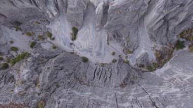Hava manzarası erozyon süreçlerini yakalıyor yıpranmış gri kayalık araziyi yontuyor, engebeli arazide jeolojik dönüşümü ortaya çıkarıyor..