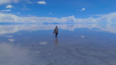 Bolivya 'daki geniş Salar de Uyuni' de gün ortasında açık bir gökyüzü altında yakalanan tek bir kişi görülüyor..
