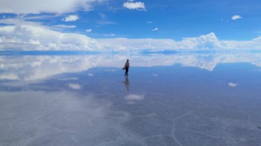 Bolivya 'daki geniş Salar de Uyuni' de gün ortasında açık bir gökyüzü altında yakalanan tek bir kişi görülüyor..