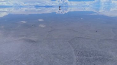 Bolivya 'daki dingin bir tuz tabakasının havadan görünüşü manzaranın genişliğini ve gökyüzünün çarpıcı yansımasını yakalıyor..