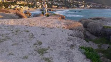 Sakin Cape Town sahil şeridinin hava manzarası, ikonik masa dağı ve sakin okyanus dalgaları.