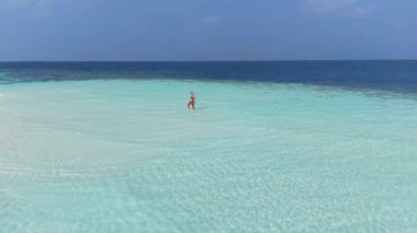 Maldivler 'de Beyaz Kum Sahilinde Yürüyen Bir Kadının Hava Görüntüsü.