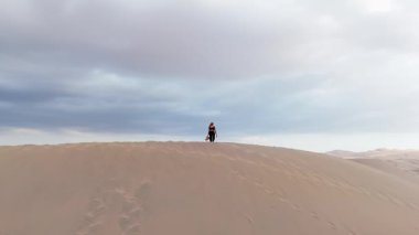 Uçsuz bucaksız kum tepeleri arasında sakin bir Peru kasabasının havadan görünüşü.