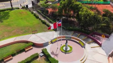 Peru, Lima 'da bir heykel ve Peru bayrağının bulunduğu sakin bir parkın havadan görüntüsü..