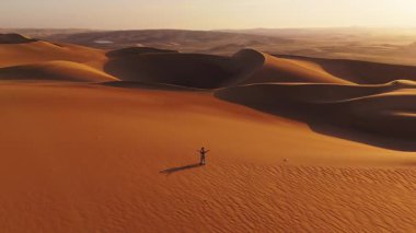 Peru 'daki kum tepelerinin günbatımında hava görüntüsü.
