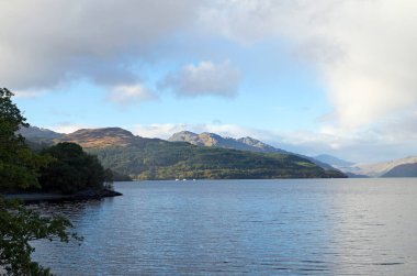 Lomond Gölü 'nün batı kıyısında, OS haritası hakemi NN 338 007, Argyll ve Bute, İskoçya' da, A82 'nin batı kıyısında bulunan Firkin Point' ten Ben Vorlich 'e kadar gölün kuzeyindeki akşam manzarası..