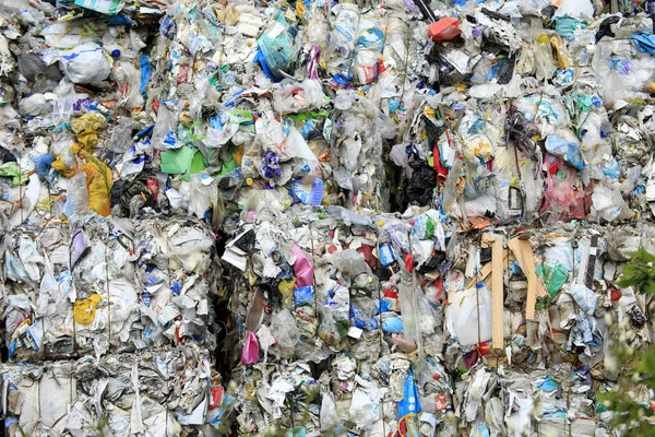 Endüstriyel geri dönüşüm tesisinde istiflenmiş plastik kırıntılarından oluşan büyük bir koleksiyonun havadan görünüşü