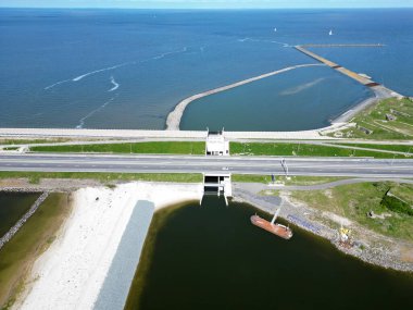 Wadden Denizi 'nden Ijssellake, Kornwerderzand, Hollanda' ya giden Afsluitdijk 'i geçerken bir balık göçü geçişinin havadan görüntüsü.