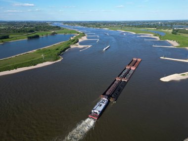 Wal nehri üzerinden Almanya, Rossum, Hollanda 'ya kömür taşıyan bir satıcının hava görüntüsü