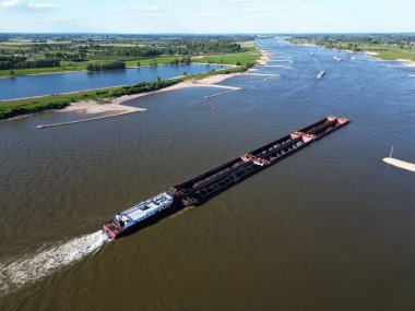 Wal nehri üzerinden Almanya, Rossum, Hollanda 'ya kömür taşıyan bir satıcının hava görüntüsü
