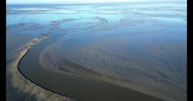 Eemsdelta, Groningen, Hollanda 'nın gelgit çamur düzlüklerinin ve kanallarının hava görüntüsü