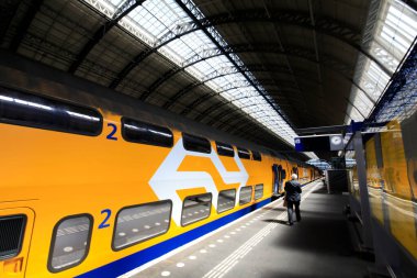 Amsterdam, Hollanda 'daki merkez tren istasyonundaki insanların uzun pozlama görüntüleri