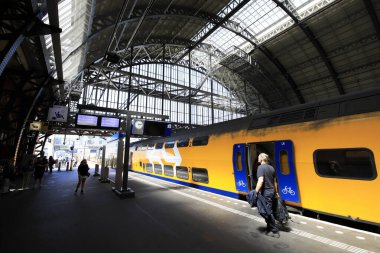 Amsterdam, Hollanda 'daki merkez tren istasyonundaki insanların uzun pozlama görüntüleri