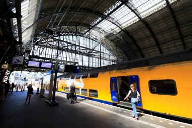 Amsterdam, Hollanda 'daki merkez tren istasyonundaki insanların uzun pozlama görüntüleri