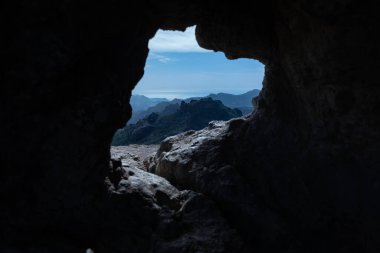 Gran Canarias 'ın nefes kesici manzarası doğal bir kaya açılışıyla çerçevelenmiş engebeli dağlar mükemmel bir macera ve keşif konsepti görüntüsü.