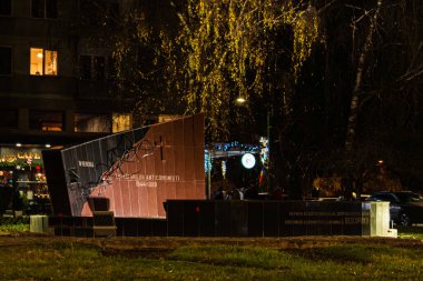 Brasov, Romanya - 6 Aralık 2025: 1944-1989 yılları arasında komünizm karşıtı savaşçılara adanmış taş heykel, Romanya 'nın Brasov kentinde bir halk parkında gece aydınlandı.